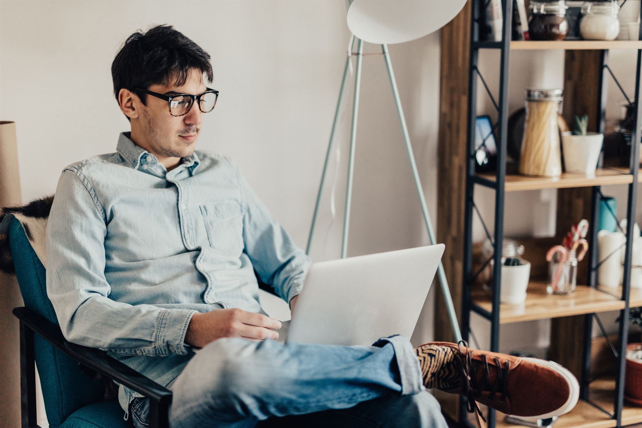 Man-using-laptop-while-sitting-in-chair